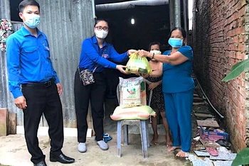 Đội hình áo xanh tình nguyện miệt rừng U Minh hạ hỗ trợ mang thực phẩm xuống nhà dân.