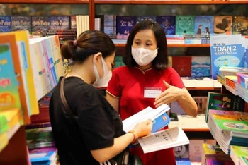 Phụ huynh lựa chọn sách giáo khoa tại hệ thống nhà sách của Nhà xuất bản Giáo dục Việt Nam. (Ảnh: Thành Tùng)