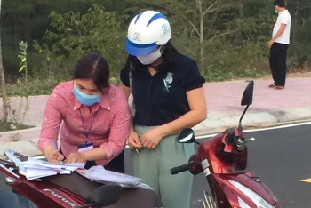 Tổ công tác xã Bình Kiến lập biên bản vi phạm hành chính về lĩnh vực y tế đối với ông Lê Xuân Hà và người phụ nữ đi cùng trên xe.