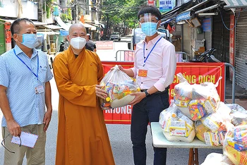 Thượng tọa Thích Thanh tuấn, Ủy viên thường trực Hội đồng Trị sự, Phó Chánh Văn phòng I Trung ương Giáo hội Phật giáo Việt Nam trao các phần quà tặng đại diện UBND phường Chương Dương. 