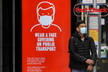 Người dân London (Anh) tuân thủ quy định đeo khẩu trang trong lúc chờ xe buýt, tháng 6/2020. (Ảnh: Reuters)