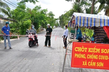 Người dân và lực lượng chức năng bảo vệ chốt “vùng xanh” tại xã Cẩm Sơn, huyện Cai Lậy (Tiền Giang).