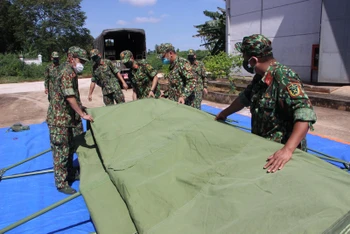 Các chiến sĩ thuộc Bộ Tư lệnh TP Hồ Chí Minh thực hành dựng nhà bạt tại kho dự trữ nhà nước tại huyện Định Quán (Đồng Nai). 