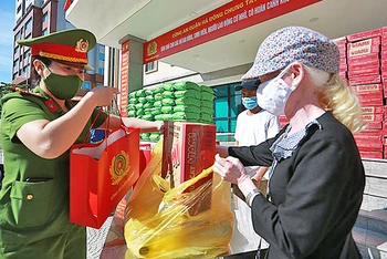 Các chiến sĩ công an quận Hà Đông trao quà tặng người dân có hoàn cảnh khó khăn.