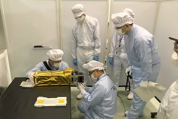 Các chuyên gia Nhật Bản lắp đặt vệ tinh NanoDragon của Việt Nam vào ống phóng của tên lửa.