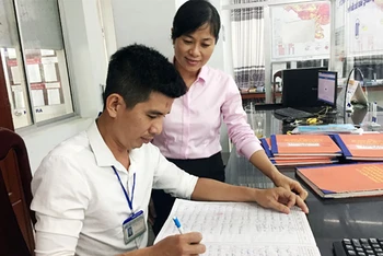 Đồng chí Nguyễn Thị Ái Hoa, Chánh Văn phòng HĐND và UBND quận Ô Môn trao đổi với cán bộ bộ phận một cửa quận.