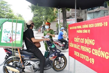 Kiểm tra giấy đi đường của người dân trên một tuyến đường ở quận Ba Đình, Hà Nội.