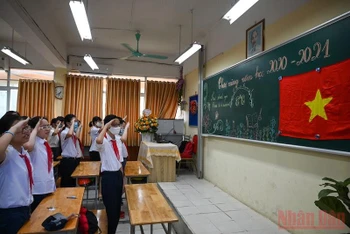 Học sinh Hà Nội thực hiện nghi thức chào cờ tại lớp học trong Lễ khai giảng năm học 2020-2021. Ảnh: DUY LINH