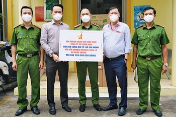 Chủ tịch Hội Doanh nhân trẻ Việt Nam Đặng Hồng Anh (thứ 2 từ trái sang) trao kít xét nghiệm và khẩu trang tặng các cán bộ, chiến sĩ công an TP Hồ Chí Minh.