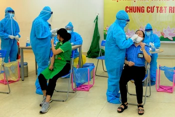 Nhân viên y tế lấy mẫu xét nghiệm Covid-19 cho nhân viên bảo vệ nhân viên bán hàng siêu thị Co.op mart Vĩnh Hưng, phường Vĩnh Hưng, quận Hoàng Mai. (Ảnh: Đăng Khoa)