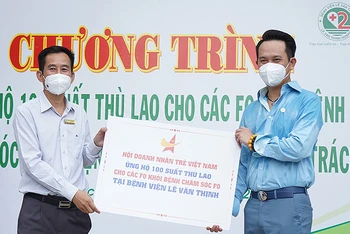 Chủ tịch Hội Doanh nhân trẻ Việt Nam Đặng Hồng Anh (bên phải trong ảnh) trao kinh phí hỗ trợ 100 tình nguyện viên chương trình “ATM F0 chống dịch”.
