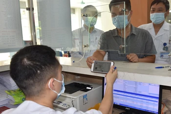 Người dân đăng ký khám, chữa bệnh tại Bệnh viện đa khoa Hà Đông bằng thẻ bảo hiểm y tế trên ứng dụng VssID. 