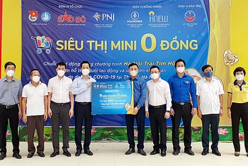 Đại diện Ban Tổ chức “Siêu thị mini 0 đồng” trao 800 phiếu mua hàng tặng đại diện chính quyền quận Hoàn Kiếm.
