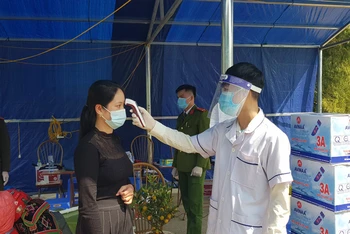 Lực lượng chức năng tại chốt kiểm soát Pha Đin (huyện Tuần Giáo, tỉnh Điện Biên) kiểm tra thân nhiệt người vào địa bàn.
