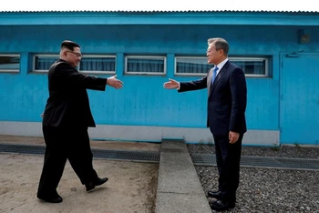 Tổng thống Hàn Quốc Moon Jae-in và nhà lãnh đạo Triều Tiên Kim Jong-un bắt tay nhau tại làng đình chiến Panmunjom, ngày 27/4/2018. (Ảnh: Reuters)
