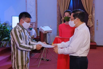 Đồng chí Phạm Bình Minh, Uỷ viên Bộ Chính trị, Phó Thủ tướng Chính phủ, Chủ tịch Hội đồng Tư vấn đặc xá trao Giấy chứng nhận đặc xá cho phạm nhân.