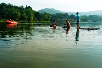 Lực lượng chức năng tìm, vớt nạn nhân đuối nước trong hồ ở xã Đồng Thịnh, huyện Ngọc Lặc.