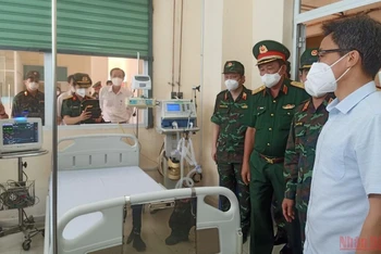 Phó Thủ tướng Vũ Đức Đam (áo trắng bên phải) thăm một phòng điều trị bệnh nhân Covid-19 tại Bệnh viện dã chiến truyền nhiễm 5G. (Ảnh: CTV)