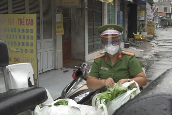 Nữ cảnh sát khu vực Đinh Thị Diệu Hạnh đi chợ giúp dân trong lúc thực hiện giãn cách xã hội.