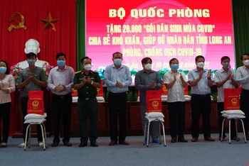 Đại diện Bộ Quốc phòng trao quà cho người lao động khó khăn trên địa bàn huyện Châu Thành (Long An). (Ảnh: THANH PHONG).