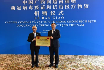 Đại sứ Việt Nam tại Trung Quốc Phạm Sao Mai (trái) thay mặt tiếp nhận số hàng viện trợ từ Phó Chủ tịch Chính quyền Khu tự trị Dân tộc Choang Quảng Tây Hoàng Tuấn Hoa. (Ảnh: Mạnh Cường - TTXVN)