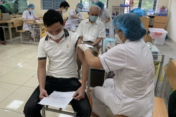 Cán bộ y tế tiêm vaccine phòng Covid-19 cho người dân quận Ba Đình.