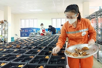 Những người thợ điện trong đồng phục màu cam đặc trưng chuẩn bị các suất ăn gửi tặng đồng bào có hoàn cảnh khó khăn.