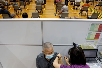 Tiêm vaccine ngừa Covid-19 ở Singapore. (Ảnh: Reuters)