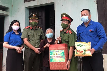 Đoàn công tác của thanh niên Công an Thủ đô trao quà tặng người già neo đơn tại xã Kim Nỗ, huyện Đông Anh (Hà Nội).