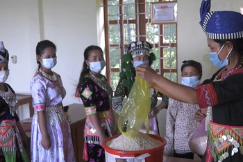 Phụ nữ bản Huồi Viêng xã Đoọc Mạy, huyện Kỳ Sơn góp gạo hỗ trợ hội viên nghèo.