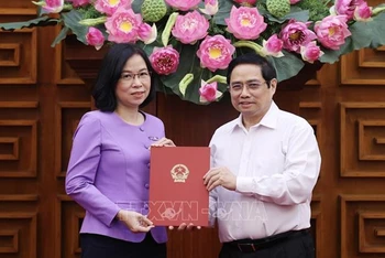 Thủ tướng Phạm Minh Chính trao Quyết định bổ nhiệm Tổng Giám đốc TTXVN cho bà Vũ Việt Trang. (Ảnh: TTXVN)