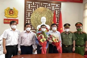 Đại diện Công an tỉnh An Giang tặng hoa cảm ơn Công ty ANGIMEX đã hỗ trợ người dân huyện An Phú.