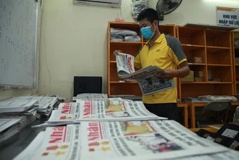 Nhân viên Bưu điện Việt Nam thực hiện khai thác, chia chọn báo trước khi đi phát. Ảnh: Vietnam Post.