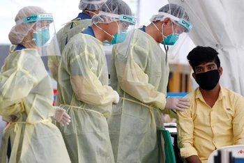 Nhân viên y tế chuẩn bị lấy mẫu xét nghiệm Covid-19 của lao động nhập cư tại Singapore, ngày 15/5/2020. (Ảnh: Reuters)