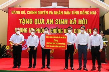 Bí thư Tỉnh ủy Đồng Nai Nguyễn Hồng Lĩnh trao bảng tượng trưng 500 phần quà cho lãnh đạo TP Long Khánh trao đến tận tay người có hoàn cảnh khó khăn.