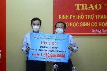 Lãnh đạo Ủy ban Mặt trận Tổ quốc Việt Nam tỉnh Quảng Ngãi trao biểu trưng hỗ trợ trang thiết bị học tập cho học sinh có hoàn cảnh khó khăn. 