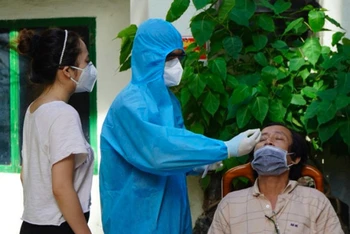 Nhân viên y tế Trung tâm kiểm soát bệnh tật TP Hồ Chí Minh hướng dẫn kỹ thuật lấy mẫu test nhanh cho người dân. (Ảnh: HCDC)