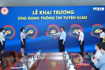 Đồng chí Nguyễn Trọng Nghĩa, Bí thư Trung ương Đảng, Trưởng Ban Tuyên giáo Trung ương và các đại biểu nhấn nút khai trương Ứng dụng Thông tin Tuyên giáo. (Ảnh: TTXVN)