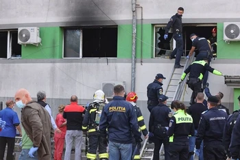 Lực lượng cứu hộ sơ tán người còn mắc kẹt trong bệnh viện sau khi đám cháy được dập tắt. (Ảnh Inquam/Reuters)
