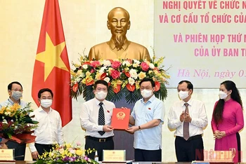 Chủ tịch Quốc hội Vương Đình Huệ trao Nghị quyết cho Viện trưởng Viện Lập pháp Nguyễn Văn Hiển. (Ảnh: Duy Linh)