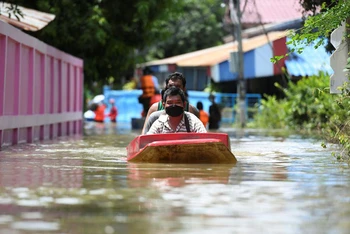 Người dân đi thuyền qua một con đường bị ngập nặng ở tỉnh Lopburi, Thái Lan. (Ảnh: Reuters)