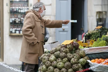 Người dân mua hàng hóa tại một khu chợ ngoài trời ở Rome, Italia, ngày 12/3/2021. (Ảnh: Reuters)