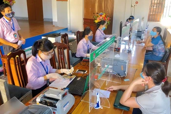 Buổi giao dịch tại xã Vạn Ninh của NHCSXH tỉnh Quảng Bình, các cán bộ luôn thực hiện quy định 5K của Bộ Y tế. (Ảnh: Tuấn Ngọc)