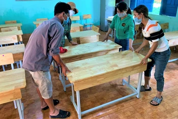 Giáo viên và phụ huynh Trường tiểu học Bùi Thị Xuân, xã vùng sâu Ea M’Droh, huyện Cư M’gar chuẩn bị bàn ghế đón học sinh đến trường học tập.