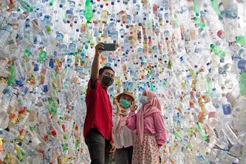 Khách tham quan chụp ảnh trong đường hầm bằng chai nhựa thu từ các con sông trong thành phố trong 3 năm qua. (Ảnh: REUTERS)