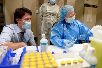 Thủ tướng J.Trudeau quan sát quy trình chiết vaccine của Pfizer-BioNTech tại một trung tâm vaccine ở Palais des Congres, ngày 15/3. (Ảnh: Reuters)