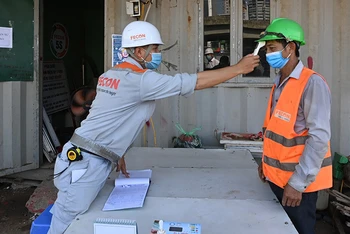 Kiểm tra thân nhiệt, khai báo y tế đối với công nhân tại công trường xây dựng hầm chui nút giao Lê Văn Lương - Khuất Duy Tiến (Hà Nội).