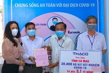 Đại diện MTTQ tỉnh Cà Mau tiếp nhận 30.000 kít test nhanh từ đơn vị tài trợ. (Ảnh: HỮU TÙNG)