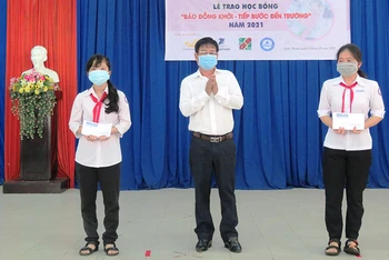 Ban tổ chức trao học bổng cho học sinh nghèo, hiếu học tại Trường THCS Tam Phước (huyện Châu Thành, tỉnh Bến Tre).