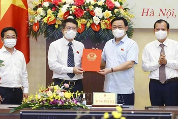Chủ tịch Quốc hội Vương Đình Huệ trao Nghị quyết cho Viện trưởng Viện Nghiên cứu lập pháp Nguyễn Văn Hiển. (Ảnh: Doãn Tấn/TTXVN)